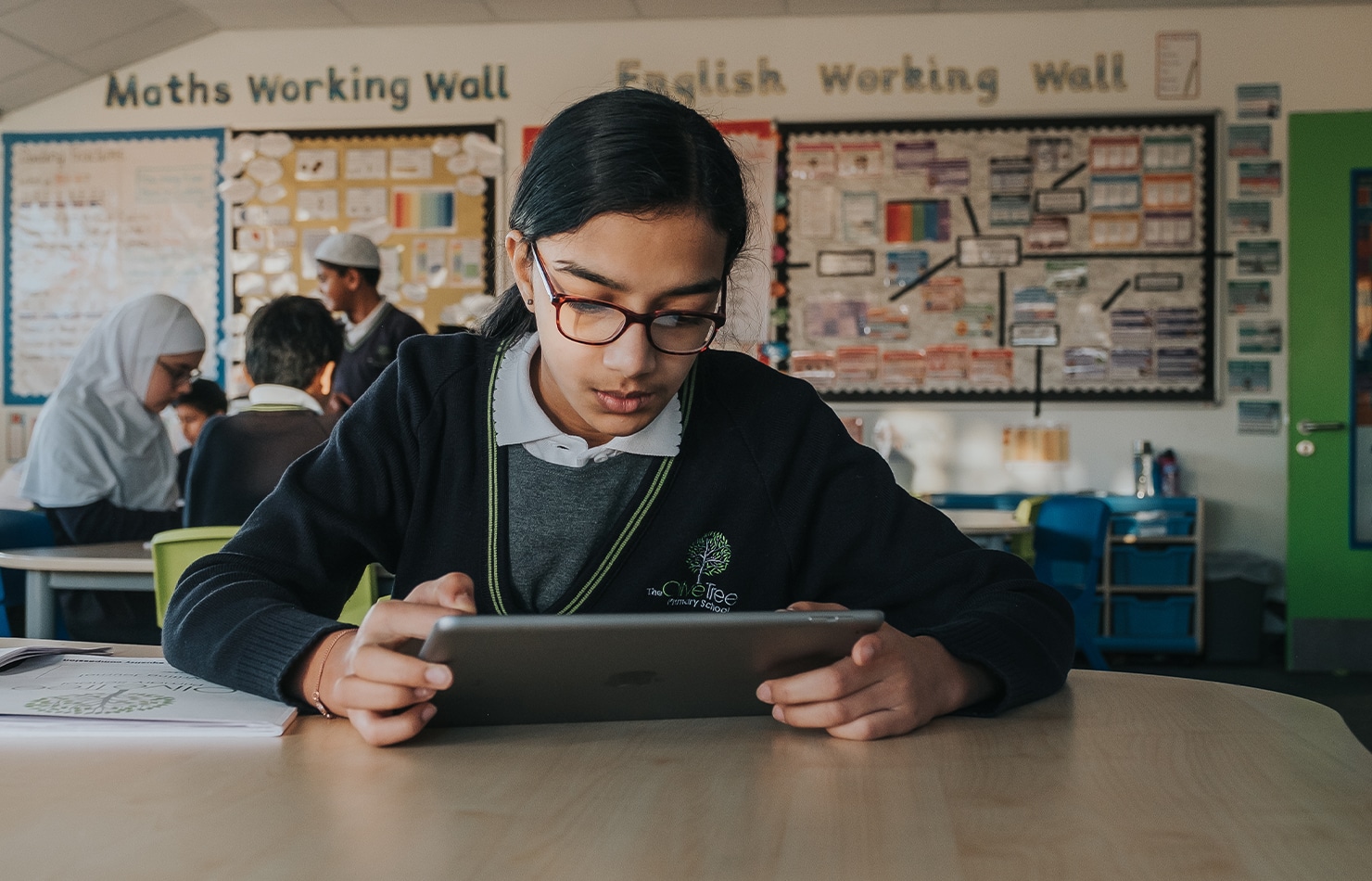 Olive Tree students works on an iPad in the classroom