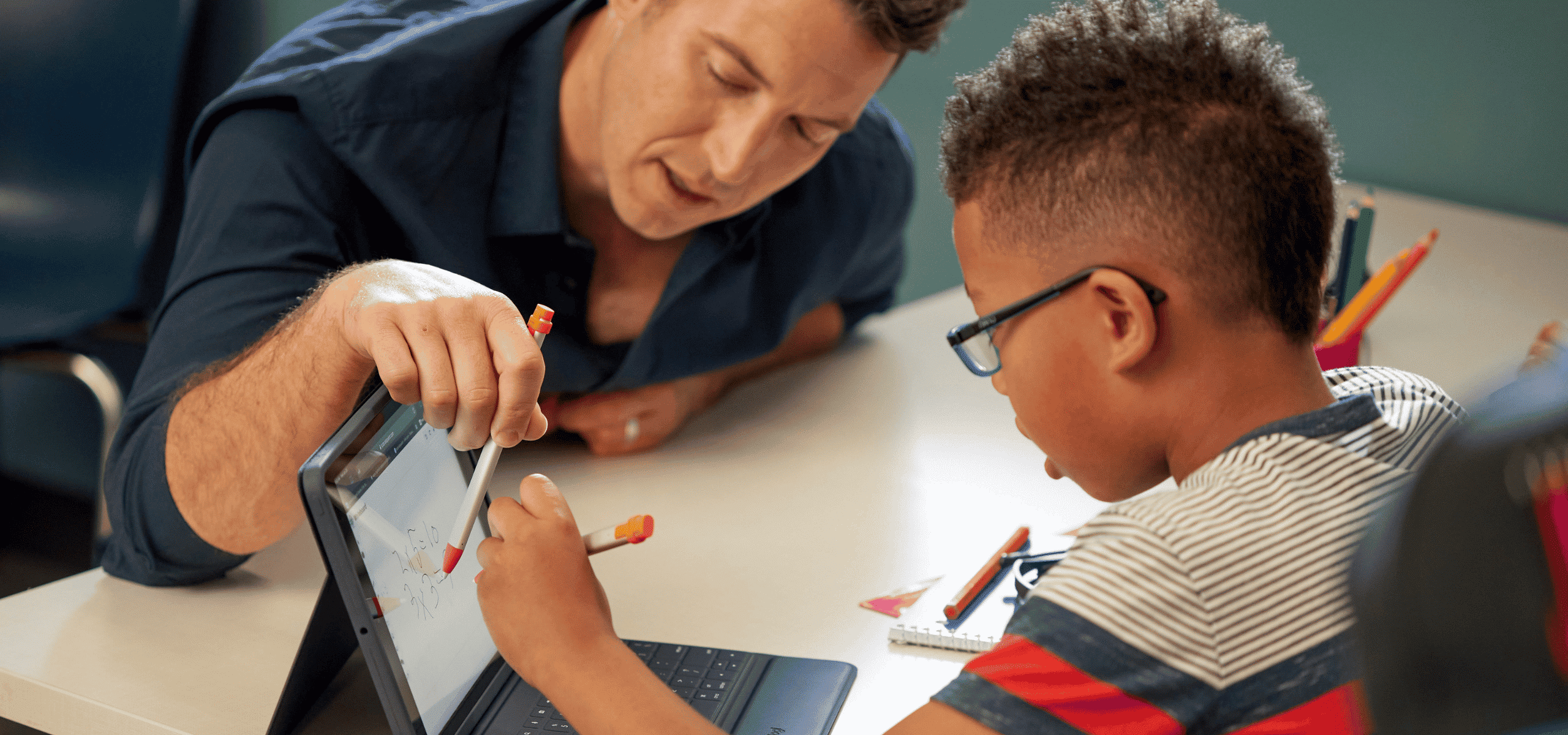 Logitech case with keyboard on iPad - teacher helping a student using logitech stylus'